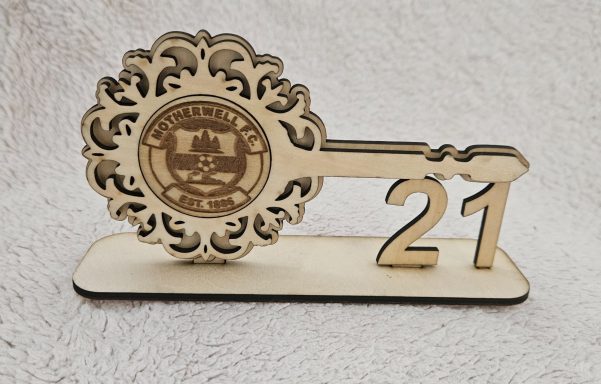 Decorative wooden key with the number 21 and a circular emblem.